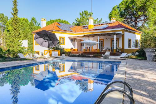 a house with a swimming pool in front of a house at Villa 97 by Trip2Portugal in Alcácer do Sal