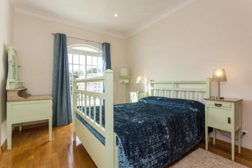 a bedroom with a bed and a desk and a window at Villa Coelho by Trip2Portugal in Olhão