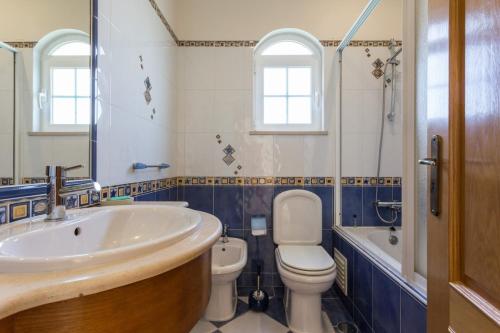a bathroom with a sink and a toilet and a tub at Villa Coelho by Trip2Portugal in Olhão