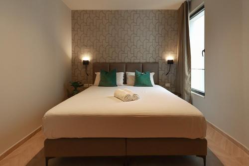 a bedroom with a large bed with green pillows at Azure Escape luxury apartments Sarande in Sarandë