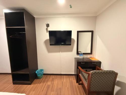 a room with a desk and a television on the wall at Swing & Pillows - Dataran Nilai in Nilai