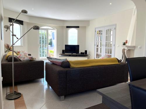 a living room with two couches and a tv at Villa Coelho by Trip2Portugal in Olhão