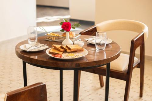 a wooden table with a plate of food on it at Spellmount - Himalayan View Infinity Pool Resort In Kausani in Kausani
