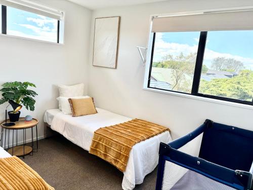 a bedroom with two beds and a window at Travellers' dream steps from shops and close to Airport in Christchurch
