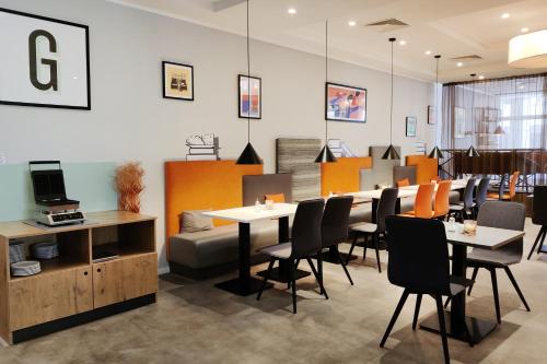 a restaurant with tables and chairs in a room at Garner Hotel Wiesbaden City by IHG in Wiesbaden
