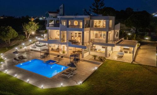 a large white house with a swimming pool at night at Monte Smith Luxury Villas in Rhodes Town