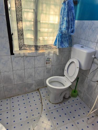 een kleine badkamer met toilet en raam bij villa luna in Watamu