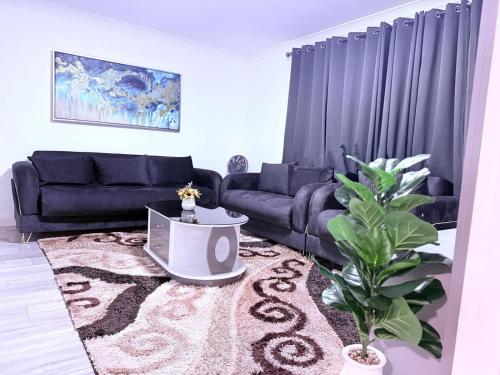 a living room with a couch and a rug at Beautiful, modern and spacious one-bedroom apartment, fully equipped with free parking in Erith