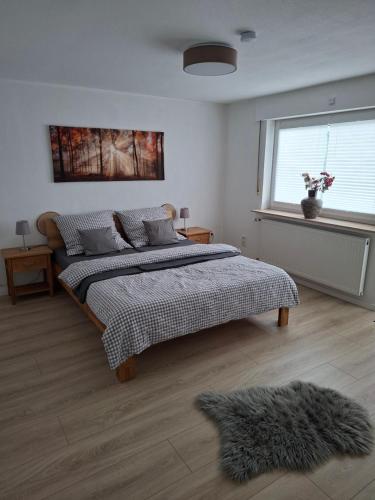 Un dormitorio con una cama grande y una ventana. en Ferienhaus Weitblick, en Olsberg