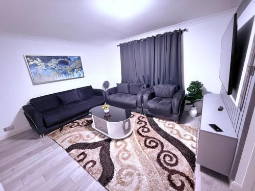 a living room with a couch and a tv at Beautiful and Spacious 1 Bedroom Apartment in Erith