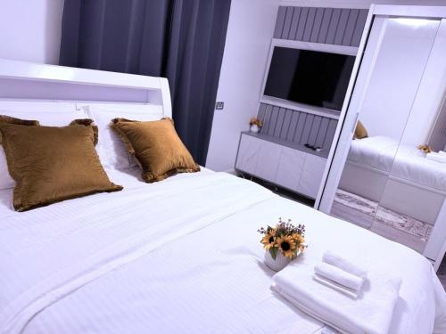 a bedroom with a large white bed with a mirror at Beautiful and Spacious 1 Bedroom Apartment in Erith