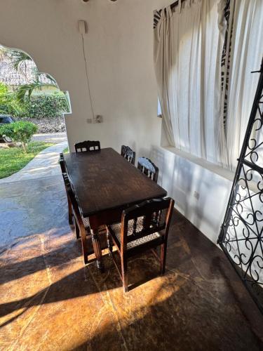 een eettafel met stoelen en een raam bij villa luna in Watamu