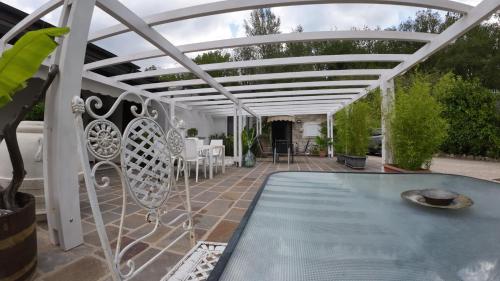 Una pérgola blanca sobre una piscina en un patio. en Tenuta le Mimose, en Benevento