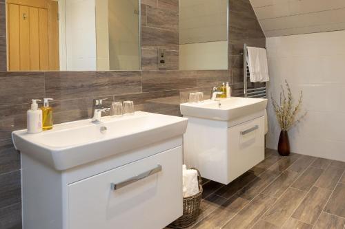 a bathroom with two sinks and a mirror at Sunset View in Innellan