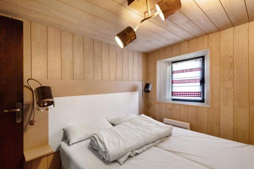 a bedroom with a white bed with a window at Maison de village Ramballade in Les Angles