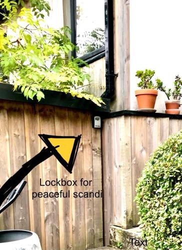 a sign on the side of a wooden fence at Peaceful Scandi Garden room in Falmouth