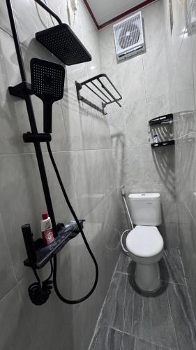 a bathroom with a toilet and a hair dryer at MH villa & hotel in Pancor