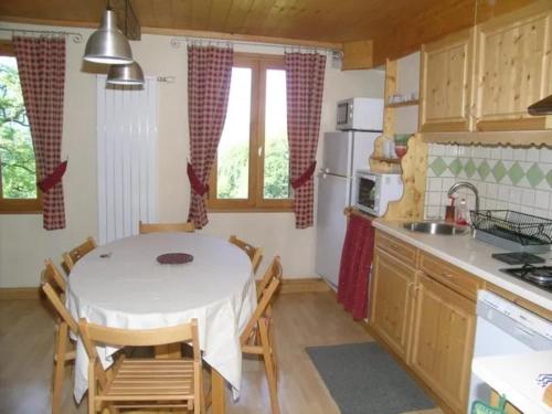 a kitchen with a table and chairs in a room at La Mutelline - Les Carroz in Arâches-la-Frasse