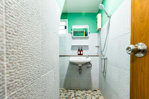 un baño con lavabo y ducha en X GO INN The Giant Swing เสาชิงช้า, en Bangkok