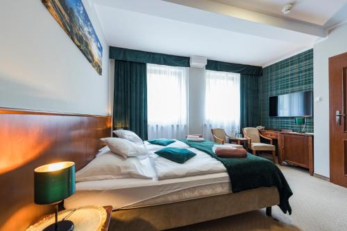 シュクラルスカ・ポレンバにあるVilla Wernera Hotel & Spaのベッドと机とテレビのある寝室