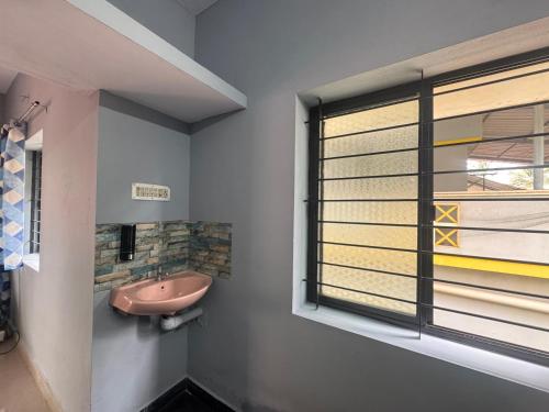 a bathroom with a pink sink and a window at ROB'S INN Groupstay 
