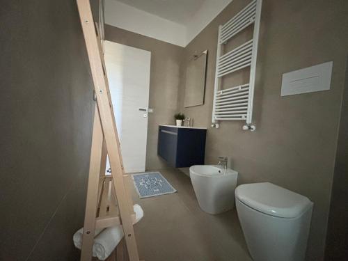 a bathroom with a white toilet and a sink at Villa Giustina Apartment Tortolì in Àrbatax