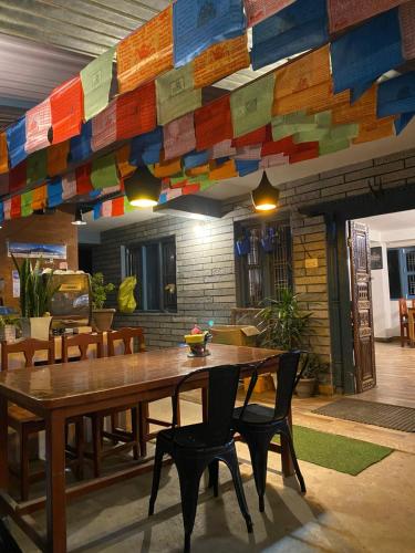 a dining room with a wooden table and chairs at Hotel aagan cafe and resturant in Astam