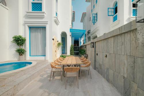 a patio with a table and chairs next to a pool at Ha Long 4BRS Beach Villa With Pool, Jacuzzi and Sauna in Ha Long