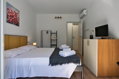 a bedroom with a large white bed and a tv at Il Papavero, raffinato, accogliente, lussuoso appartamento in Santo Stino di Livenza