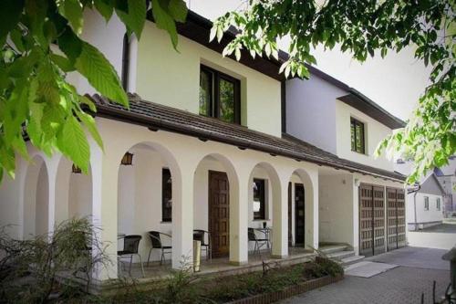 una casa blanca con mesas y sillas. en 4 friends HOSTEL, en Cracovia
