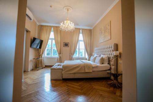 a bedroom with a large bed and a chandelier at Parkview Boutique Apartments in Vienna