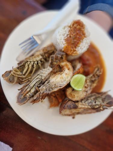 a white plate of food with seafood and a fork at Lemon grass house in Binguni