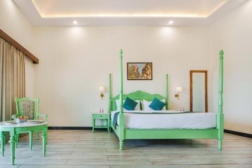 - une chambre avec un lit vert et une table dans l'établissement Sajjan Jawai Chapter by Arow Hospitality, à Mori Bera