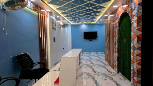 a hallway with a room with blue walls and a tv at Hotel Shiv Grand SV in Kānpur