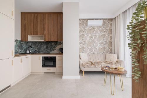 a kitchen and living room with a couch and a table at Elegant Studios in Katowice with Gym, Sauna & Cinema by Noclegi Renters in Katowice