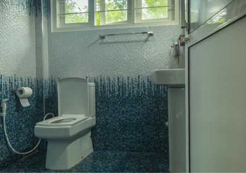 a bathroom with a toilet and a sink at Knight's Dale Knuckles Holiday Bungalow in Kandy