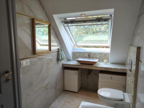 a bathroom with a toilet and a window at Villa Angelina La Baule in La Baule