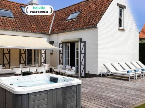 Un jacuzzi en una terraza junto a un edificio. en Luxury Villa in Sint-Idesbald with Jacuzzi, en Sint-Idesbald