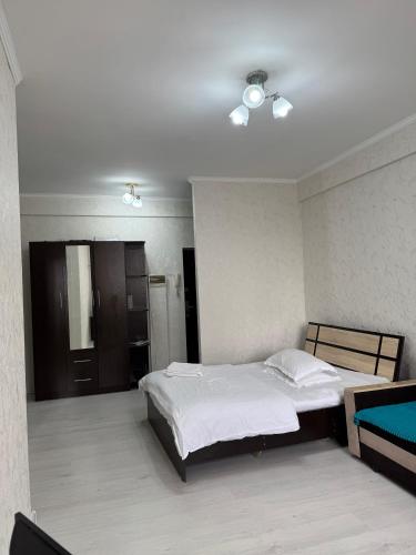 a bedroom with two beds and a ceiling at Уютная Квартира Ай in Zhezdi