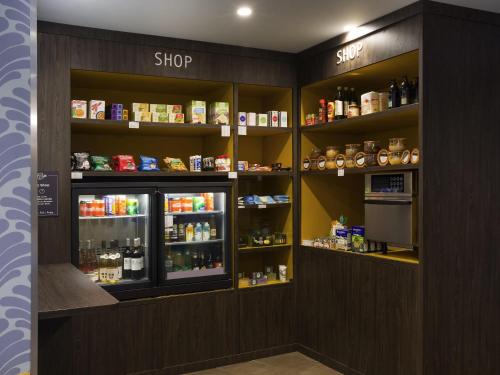 a store with a refrigerator and shelves filled with food at Aparthotel Adagio Annecy Centre in Annecy