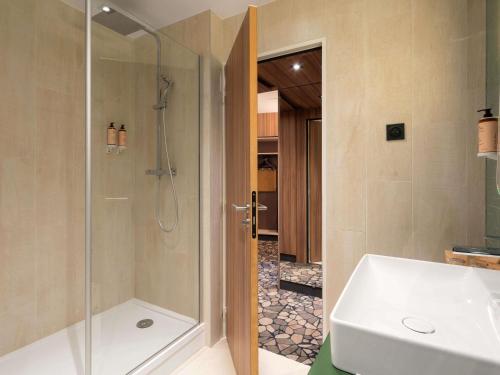 a bathroom with a shower and a sink at Mercure Libourne Saint Emilion in Libourne