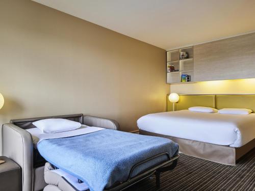 a hotel room with two beds in a room at AppartHotel Mercure Paris Boulogne in Boulogne-Billancourt