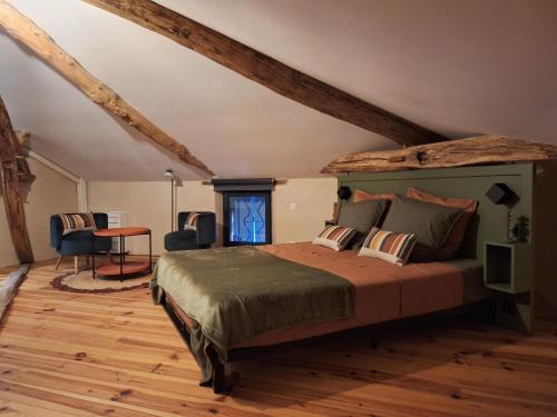 a bedroom with a bed and a table in a room at Le pigeonnier de Pauly in Mirabel