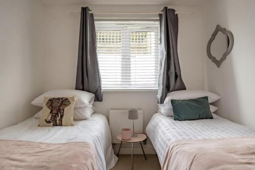 ニュートン・アボットにある2-Bed Apartment Sleeps 4 with Gardenの窓のある部屋にツインベッドが2台