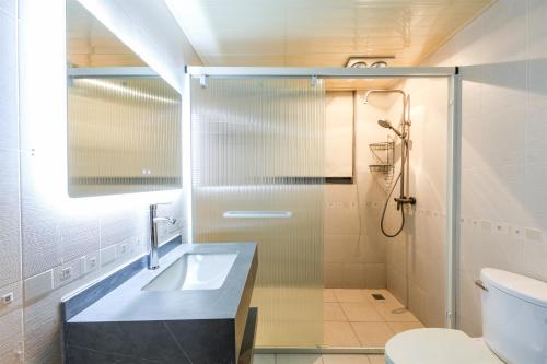 a bathroom with a sink and a shower at Baihong Riverview aparment-ChaoTianMen in Chongqing