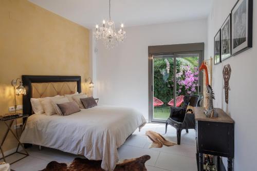 una camera da letto con un letto e un lampadario di Casa Moderna con Piscina a Palomares del Río