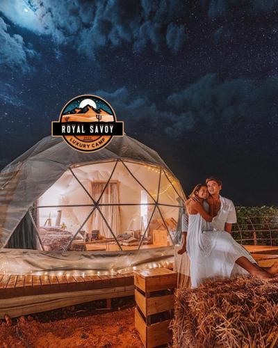 een bruid en bruidegom staan voor een yurt bij ROYAL SAVOY lUXURY CAMP in Wadi Rum