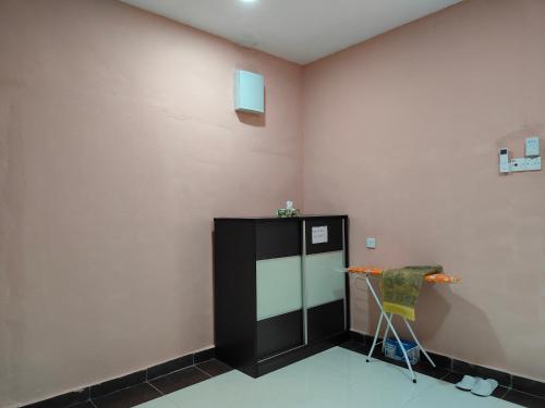 a room with a black refrigerator and a chair at Homestay Teratak Atas Bukit 
