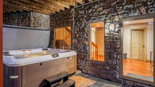 e bagno con vasca in un muro di pietra. di Lake Harmony Chalet w Hot Tub Arcades Near Beaches Ski Trails Everpine Lodge by AvantStay a Split Rock