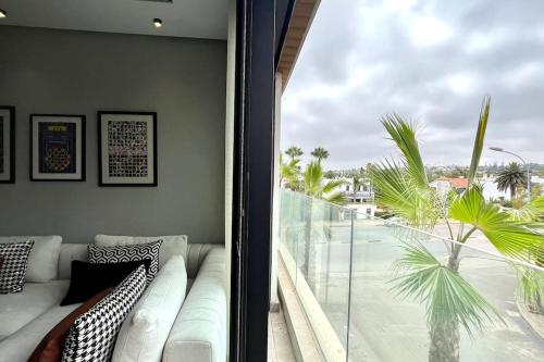 ein Wohnzimmer mit Couch und großem Fenster in der Unterkunft Anfa The Address - By AppartAli in Anfa-Supérieur